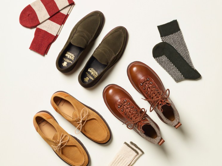 Three pairs of men's shoes in tan, olive, and brown leather displayed with striped and patterned socks