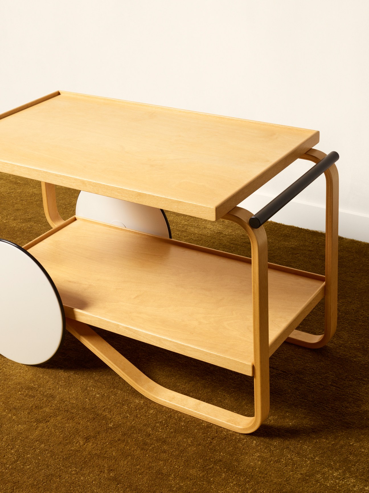 Alvar Aalto's tea trolley 901 anniversary edition in natural birch with honey lacquer and white wheels