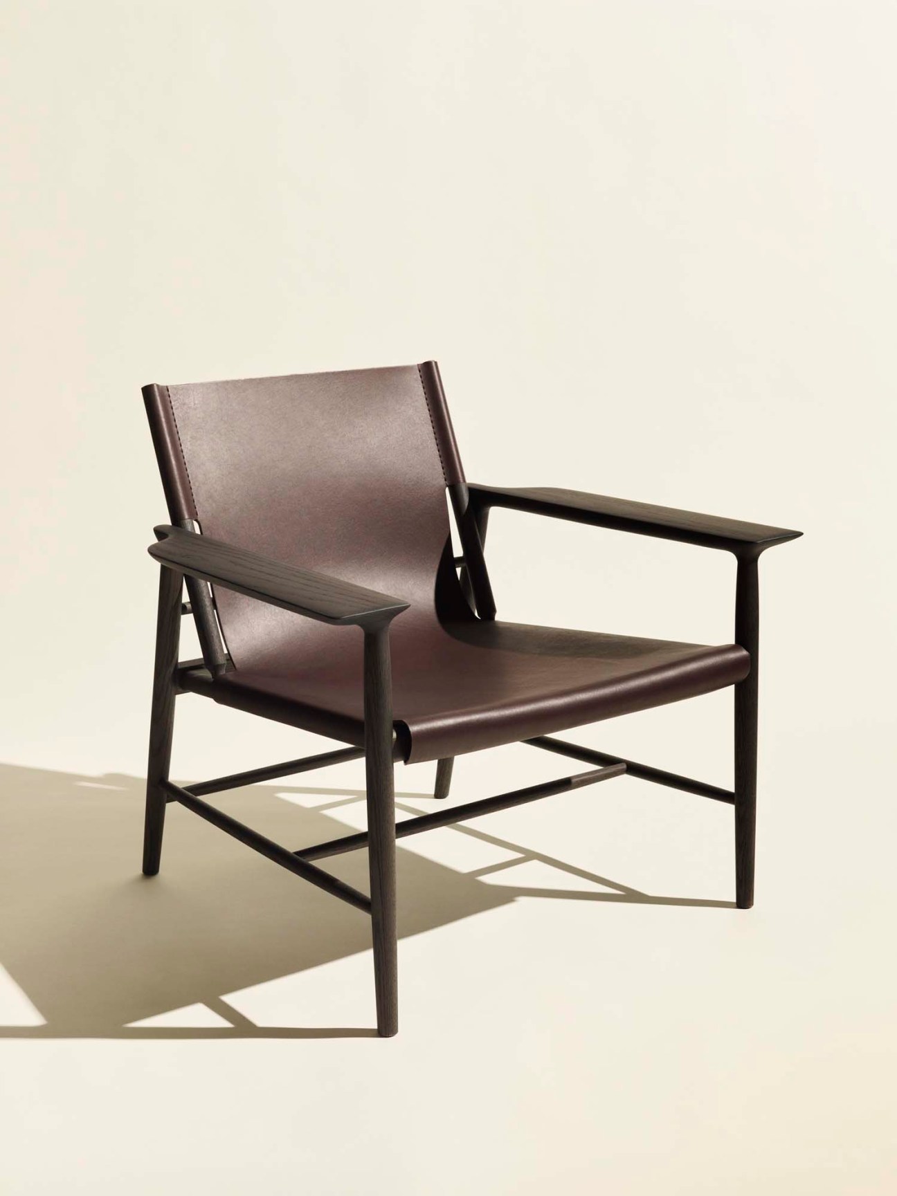 Sunset armchair by De Padova with dark wooden frame and grey leather seat