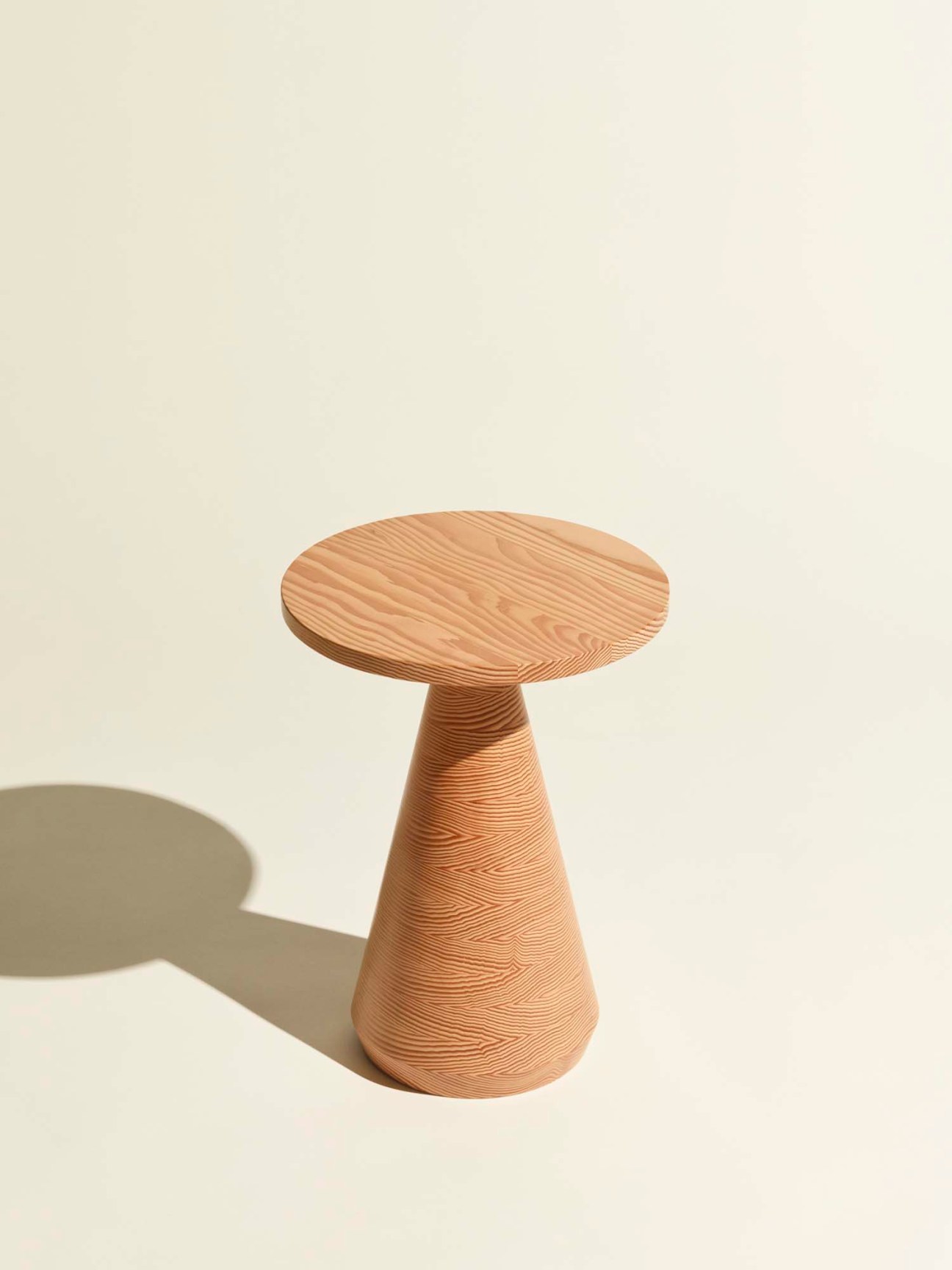 Jac side table by Anden with round wooden top and tapered cone base showing tree ring pattern