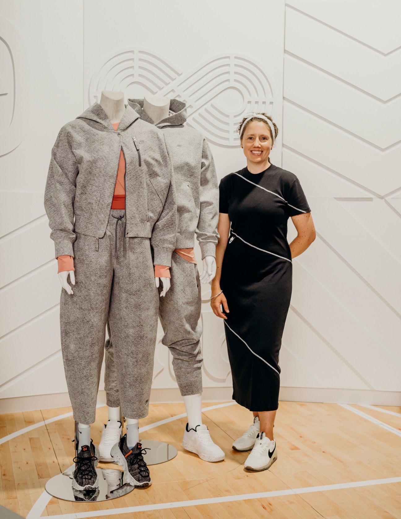 Carmen Zolman standing next to gray athletic wear displayed on mannequins in Nike design studio