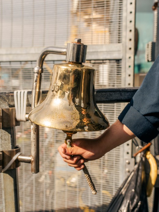 Brass bell mounted on submarine wall for ceremonial purposes