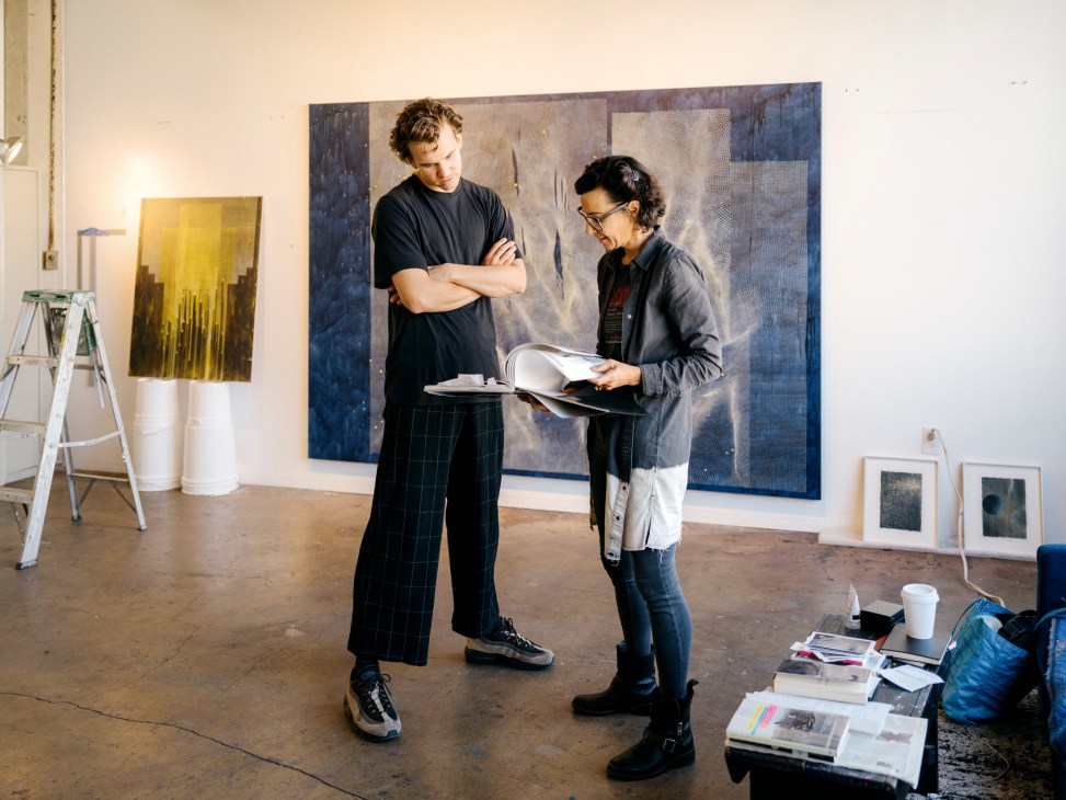 Two artists, Linn Meyers and Julian Tiso Mathews, standing together in a studio space