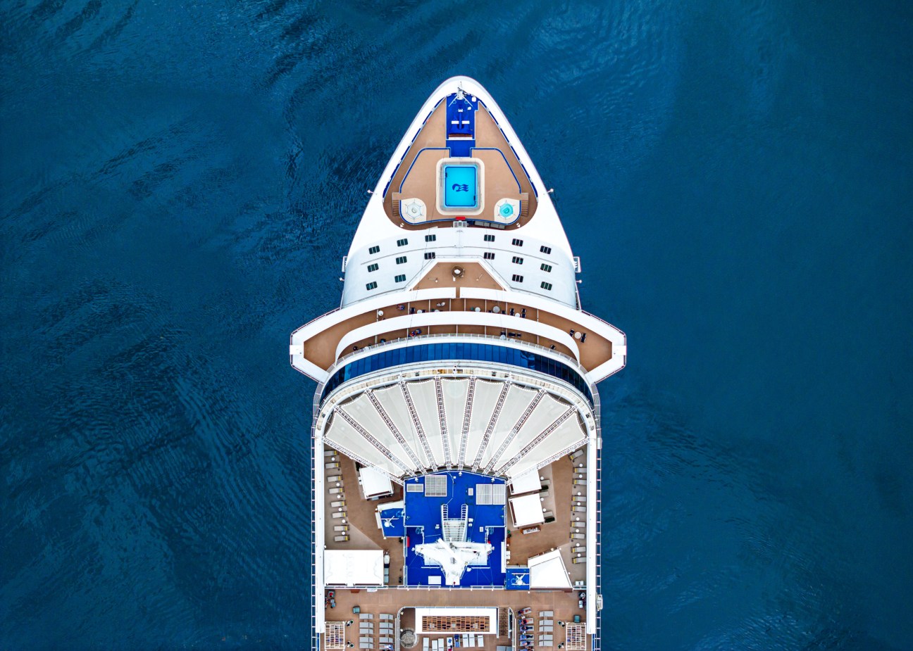 Aerial drone shot of a cruise ship deck with passengers enjoying the facilities