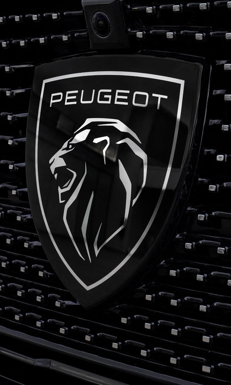 Peugeot's redesigned lion logo in white on black grille with flat, minimalist linework.