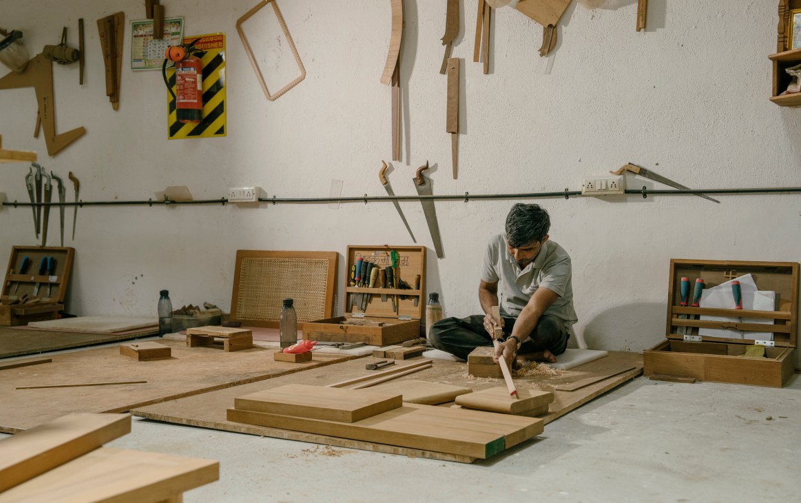 Artisan applying finishing techniques to wooden chair components
