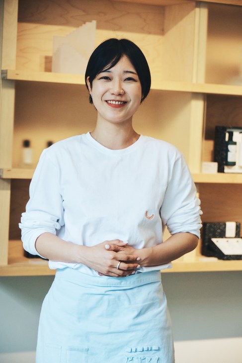 Well turned-out staff member in pale blue uniform at Nonfiction fragrance store
