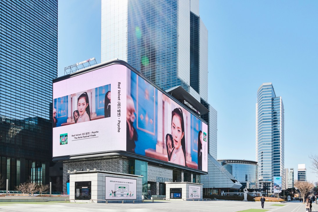 Large curved LED billboard displaying Red Velvet advertisement on modern building in Seoul's Gangnam district