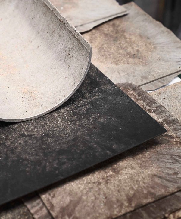 Close-up of concrete or stone surfaces with curved and angular edges showing textural details and shadows