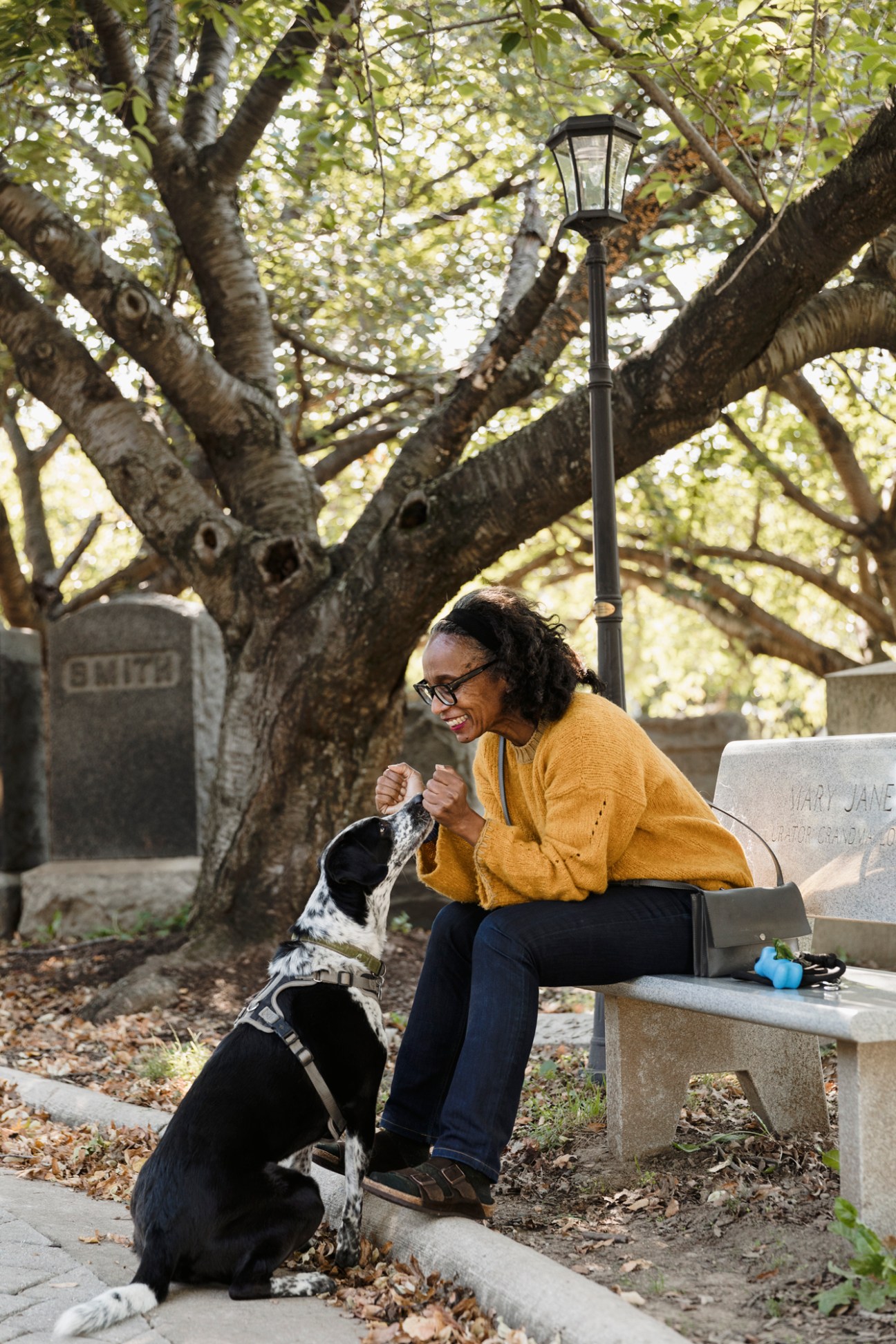 Robin Givhan sitting on cemetery bench with her German shorthaired pointer mix dog Oscar
