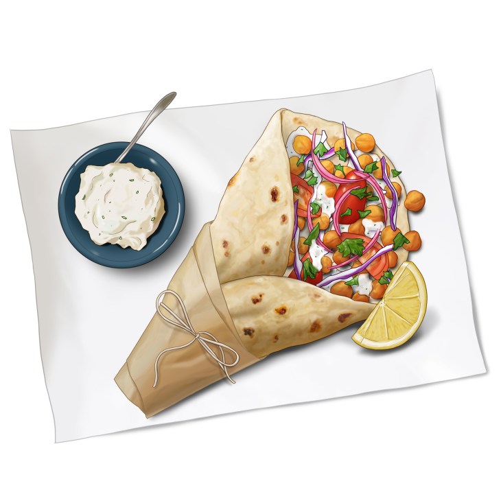 Wrapped flatbread filled with spiced chickpeas, vegetables, herbs and sauce with lemon wedge and yogurt side