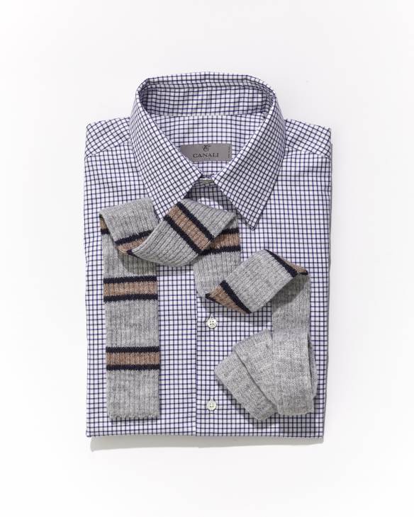 Striped knit tie draped over folded blue and white checkered dress shirt