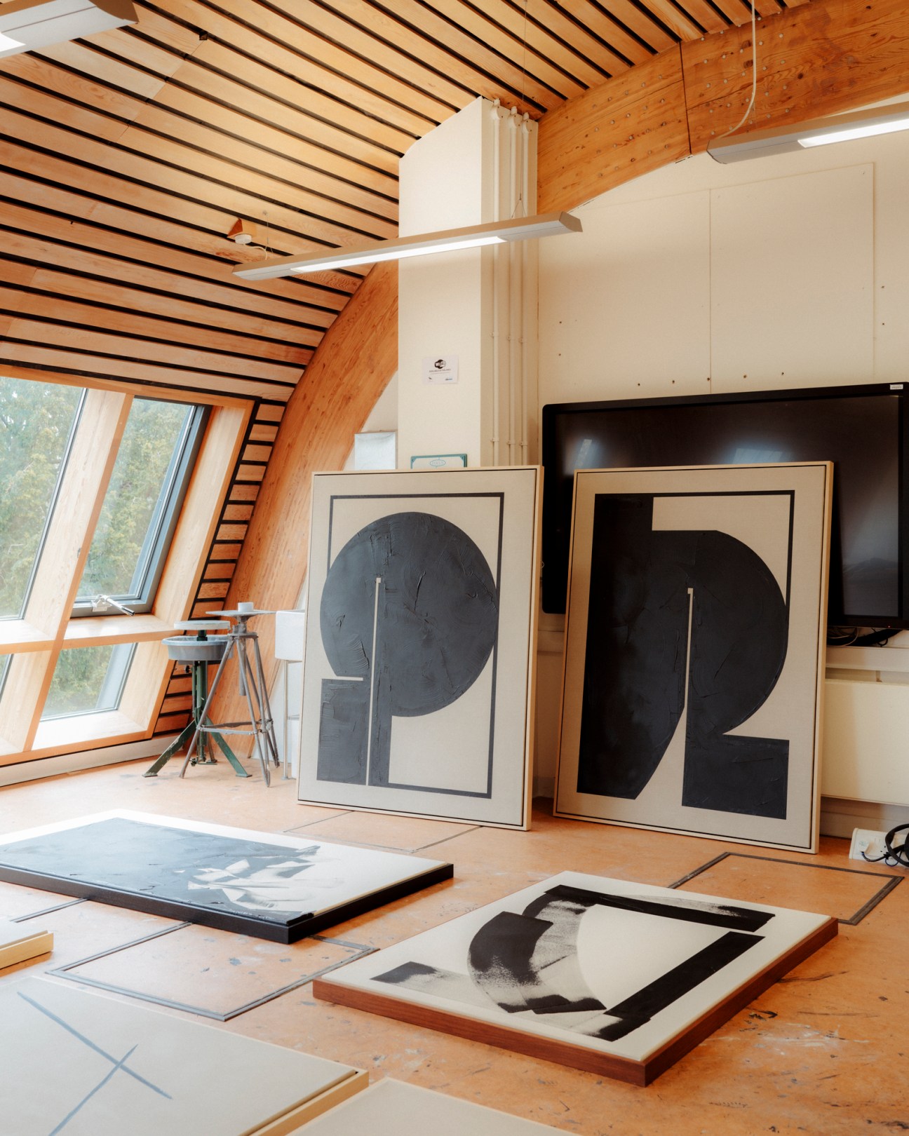 Artist Tabitha Millett in her studio at Cambridge University surrounded by geometric black and white paintings