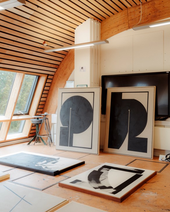 Artist Tabitha Millett in her studio at Cambridge University surrounded by geometric black and white paintings