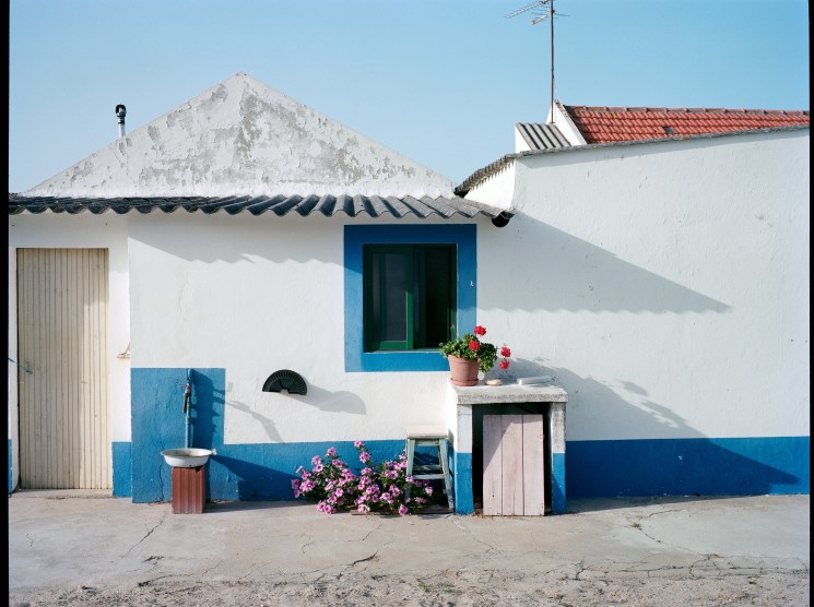 Older houses in Camporta are white-washed with blue-edged windows