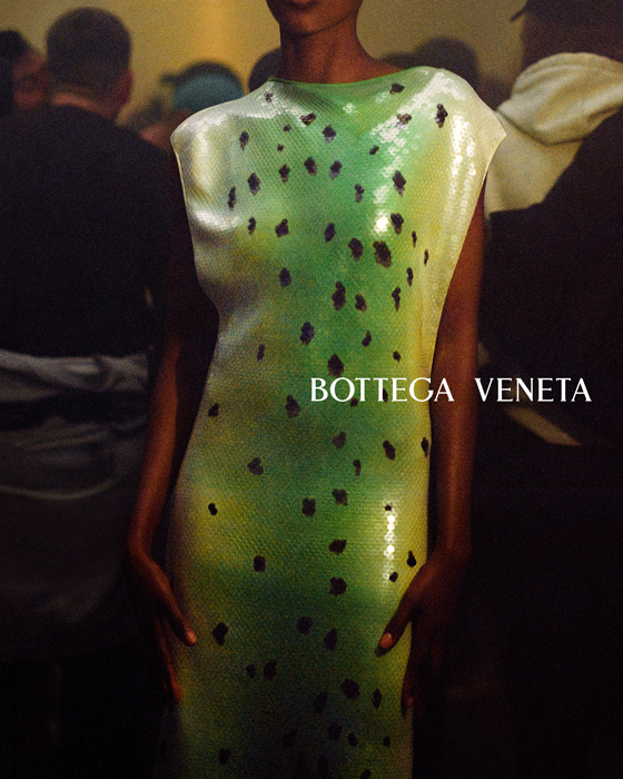 Model wearing a shimmery green dress with black spots in Bottega Veneta winter 2022 campaign