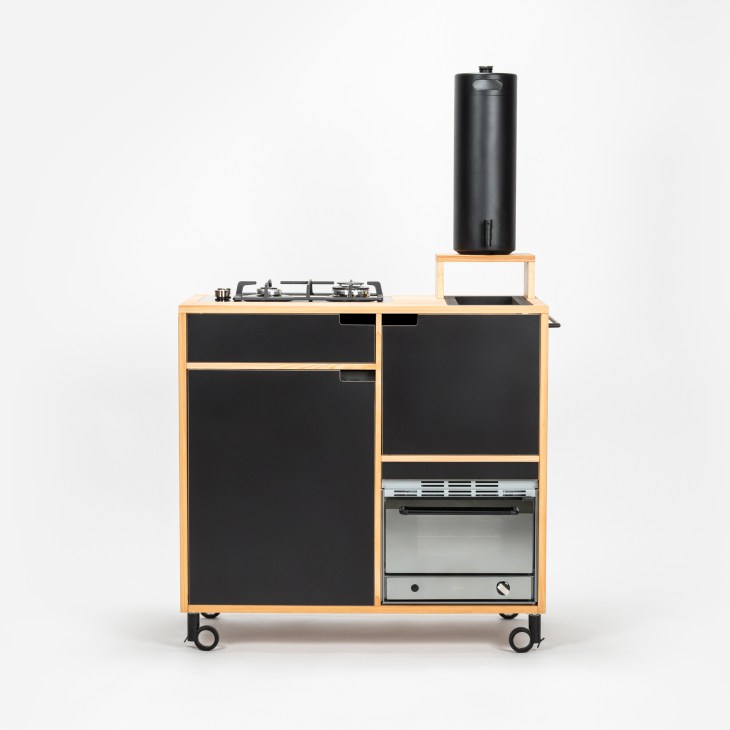 Tinyküche in natural wood finish demonstrating the space-efficient free-standing kitchen solution