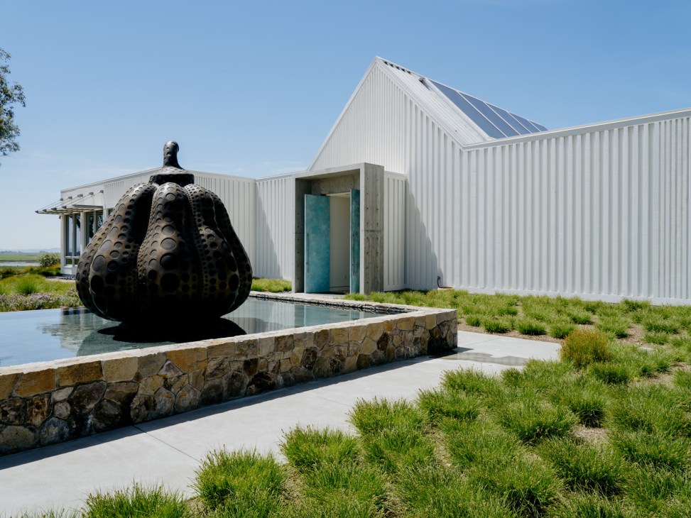 Yayoi Kusama's signature pumpkin sculpture displayed among vegetation at Donum Estate
