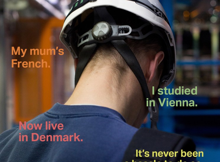 Back of person's head wearing white cyclist helmet with text overlay about European multilingualism and freedom of movement.