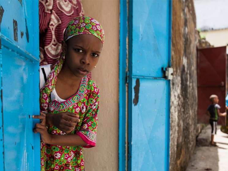 A woman and children playing in the street.