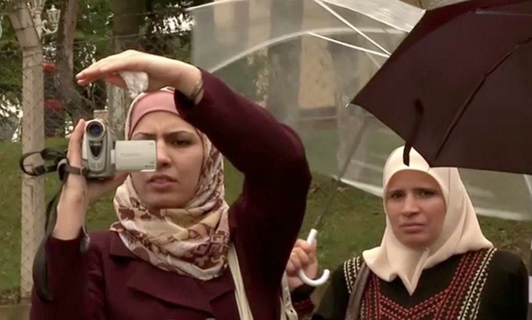 woman in burka filming