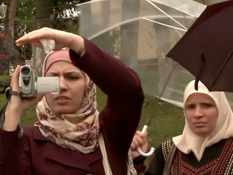 woman in burka filming