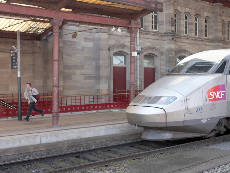 man running and train at station