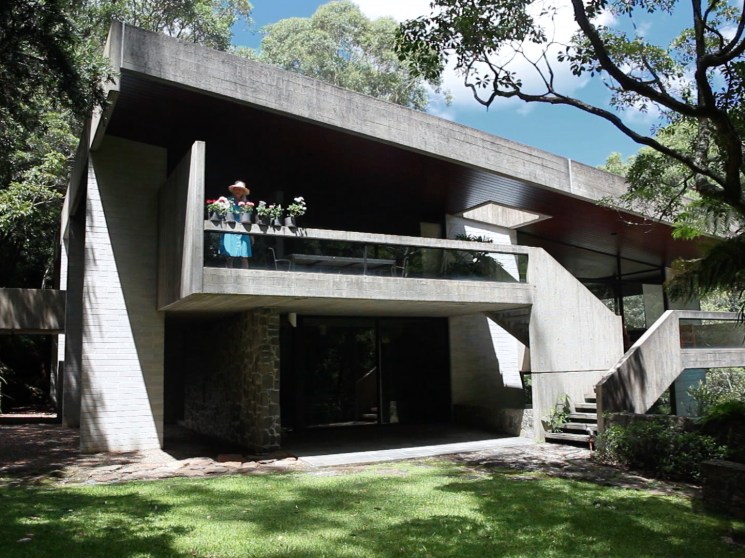 Penelope Seidler watering plants on the terrace of her house.