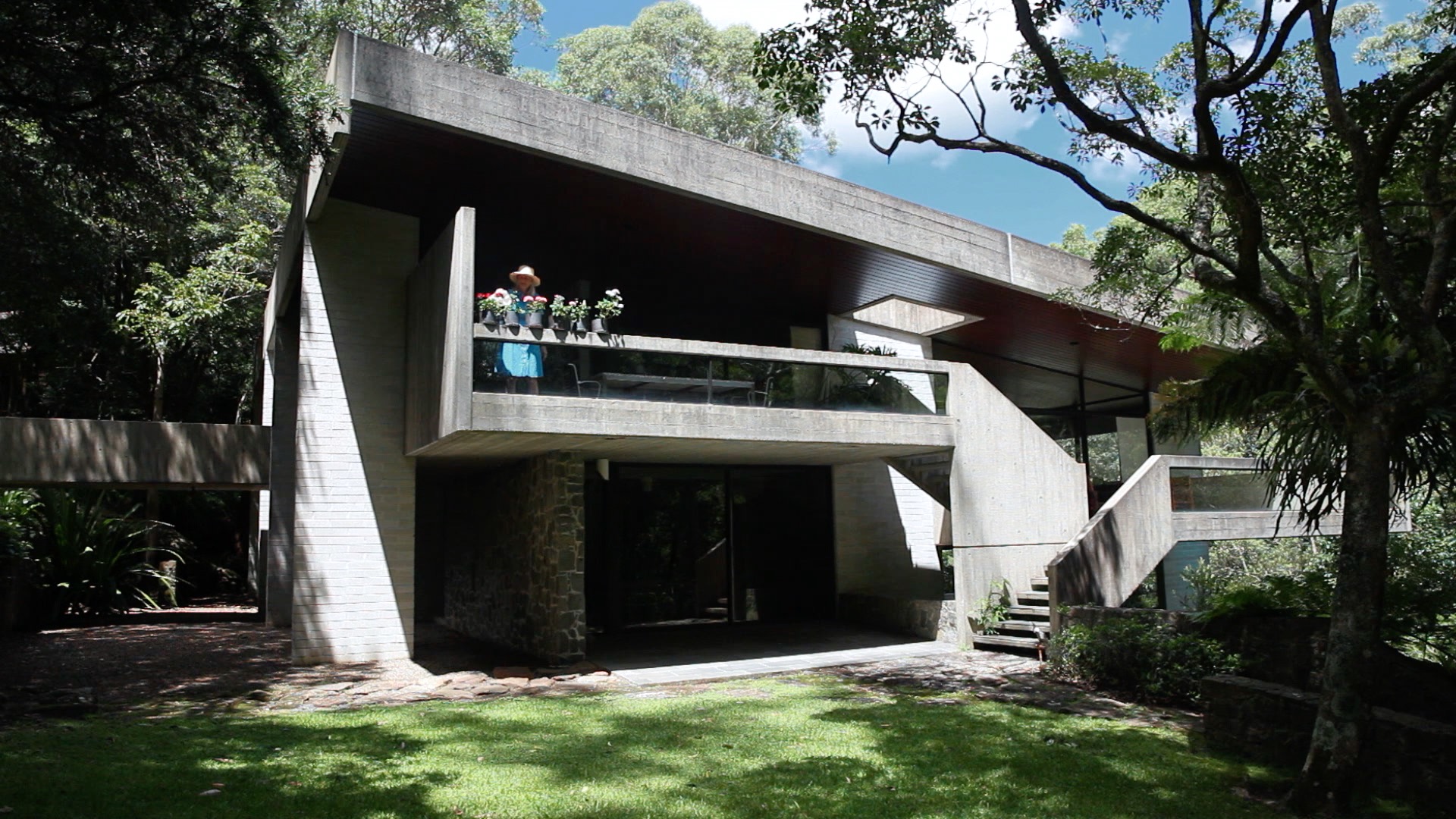 Penelope Seidler watering plants on the terrace of her house.