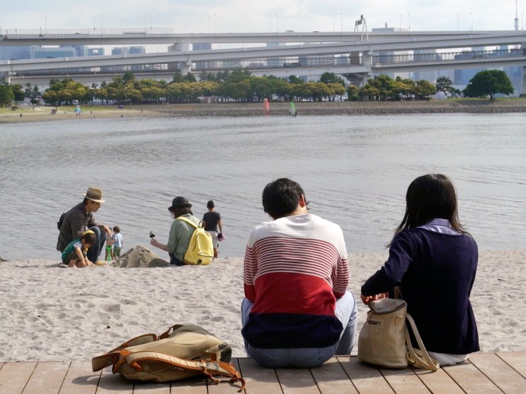 People relaxing on a beach in Tokyo.