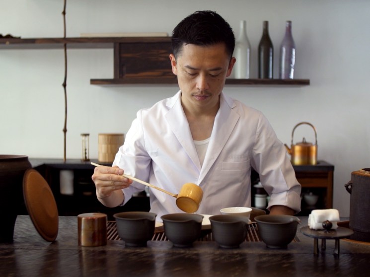 A man pouring tea into a cup.
