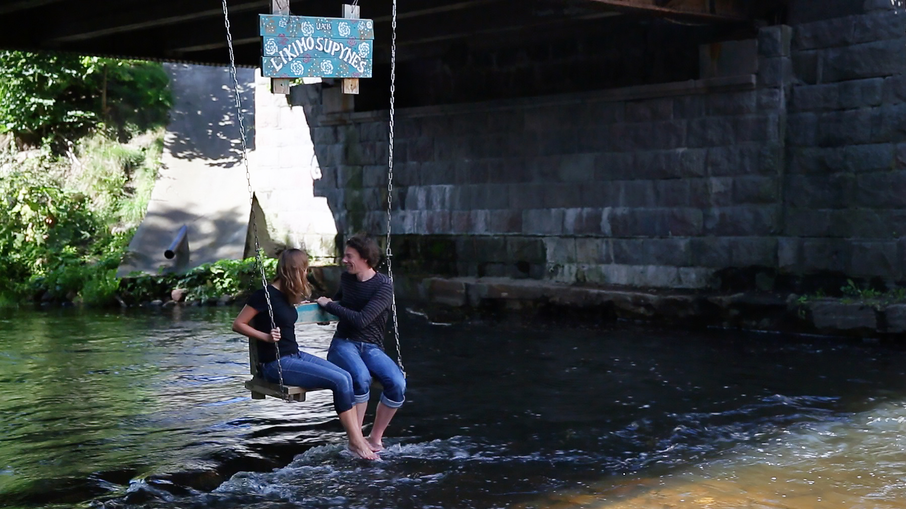 A swing hanging over the river in Uzupis.