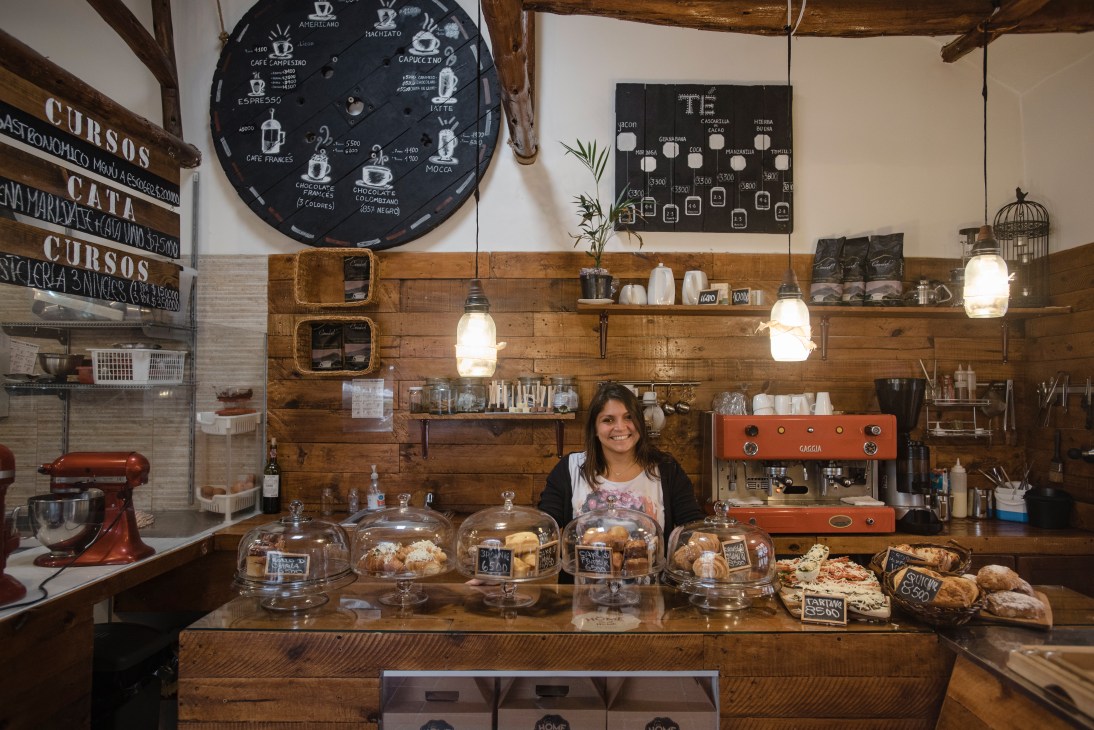 Soléne Guigal stands behind the counter of Home Sweet Home patisserie in Usaquén, Bogotá, with baked goods in glass display cases.