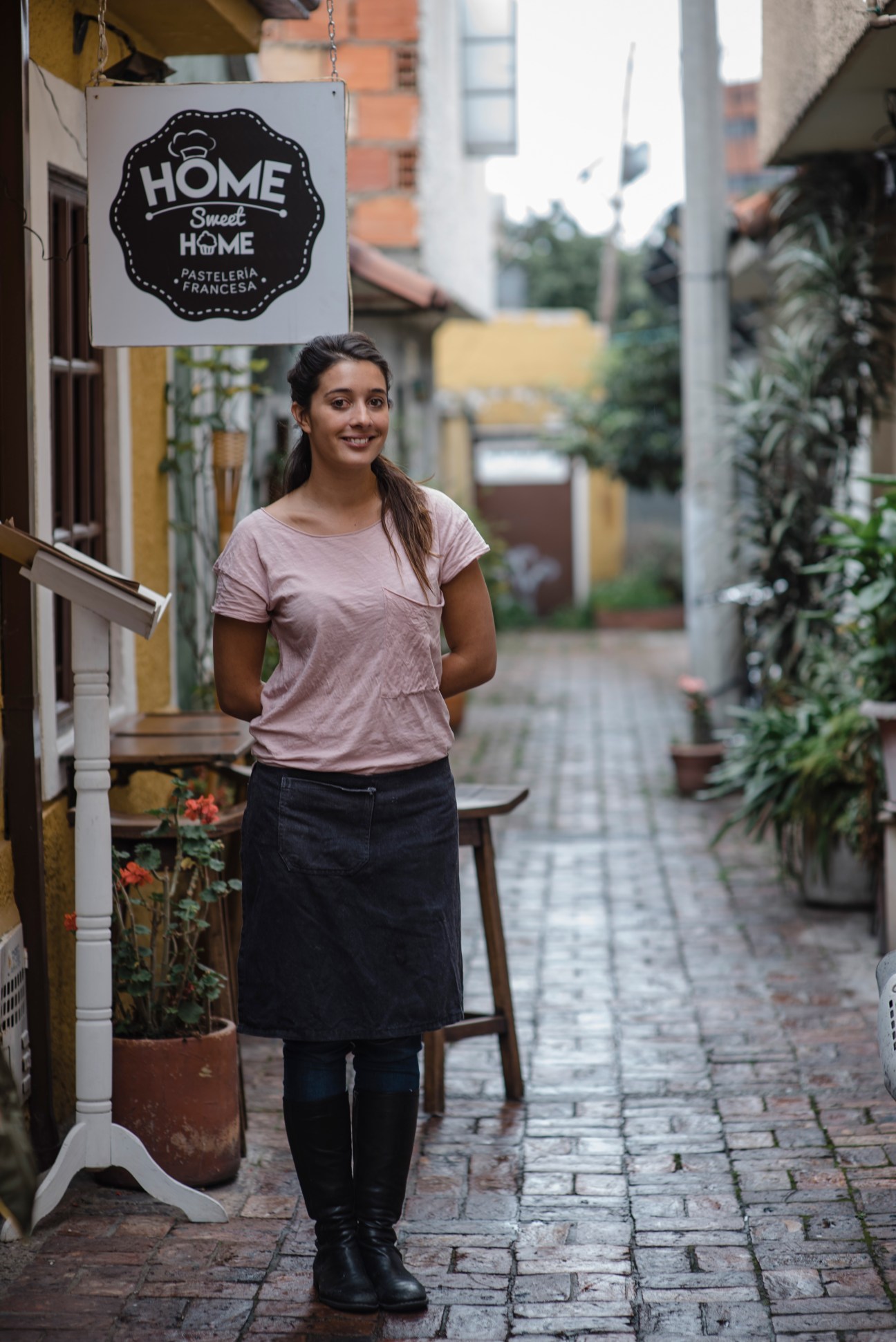 Woman standing outside Home Sweet Home patisserie in Usaquén, Bogotá
