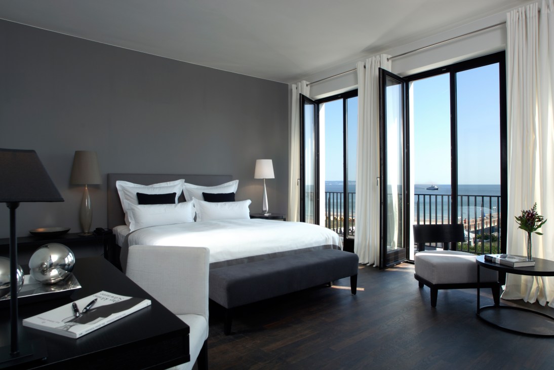 Modern hotel bedroom with sea views through floor-to-ceiling windows at Cerês am Meer.