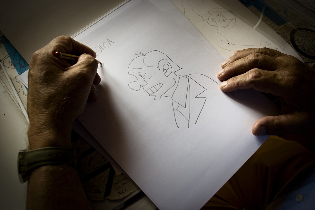Emilio Giannelli sketches a caricature of Silvio Berlusconi at his drawing board.