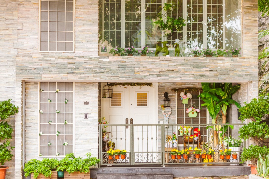 Storefront of Allure hair salon with decorative window displays and potted flowers on the ground level