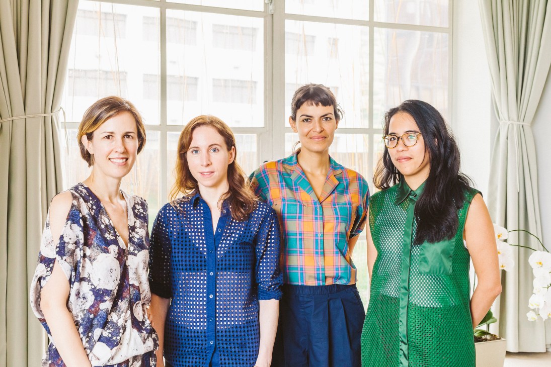 Four artists stand together in front of large windows at Spring Workshop in Hong Kong.