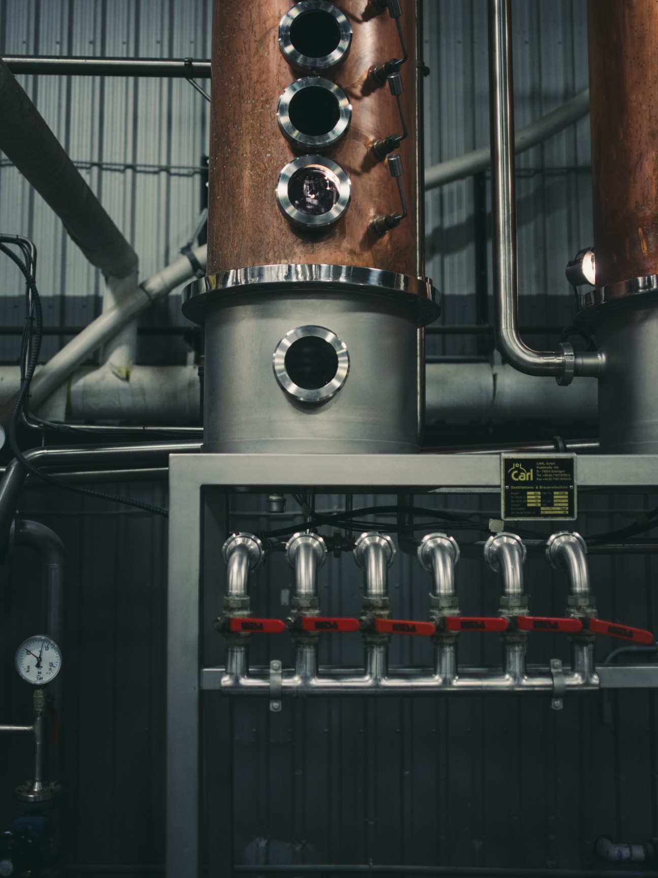 Carl copper pot still with stacked metal porthole windows at Dillon's distillery.