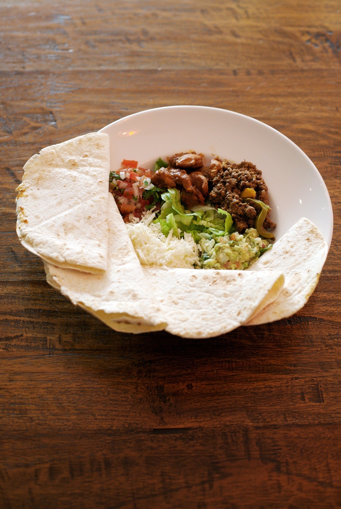 Fajitas with seasoned meat, guacamole, and fresh salsa served in warm tortillas.