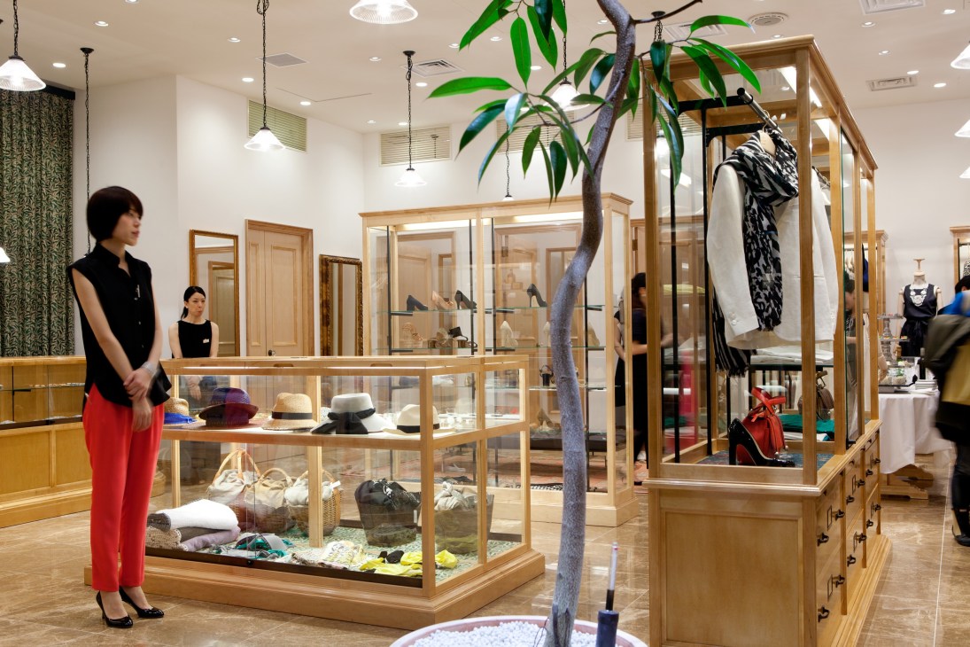Interior of La Boutique by Dressterior showing wooden display cases, clothing racks, and a woman shopping.