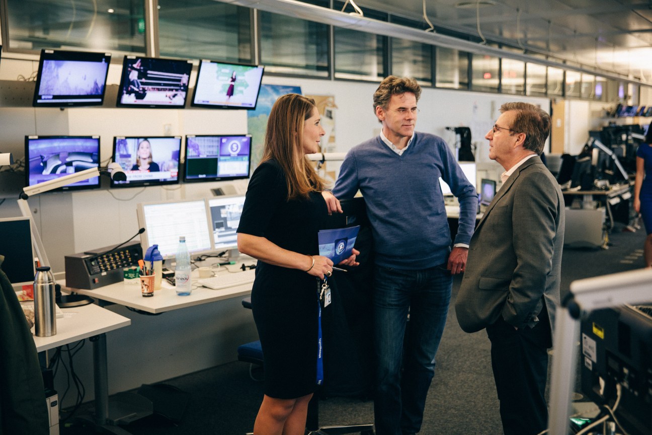 Chief presenter Jan Hofer briefs colleagues in the Tagesschau control room surrounded by monitors.