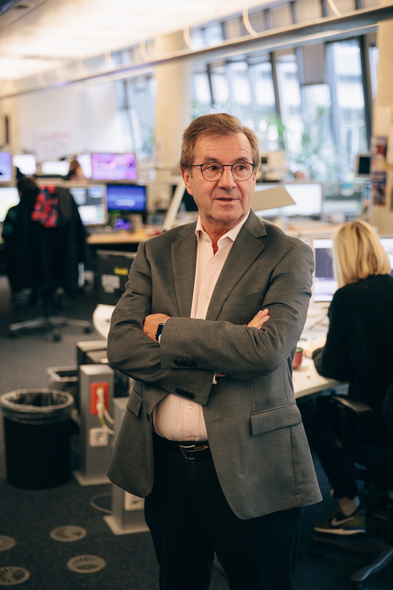 Jan Hofer, chief presenter of Tagesschau, standing in the newsroom with arms crossed.