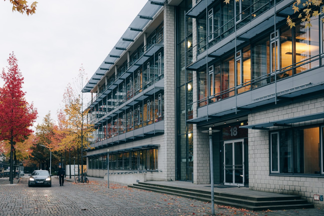 Modern multi-story brick building with large windows and autumn foliage visible in Hamburg