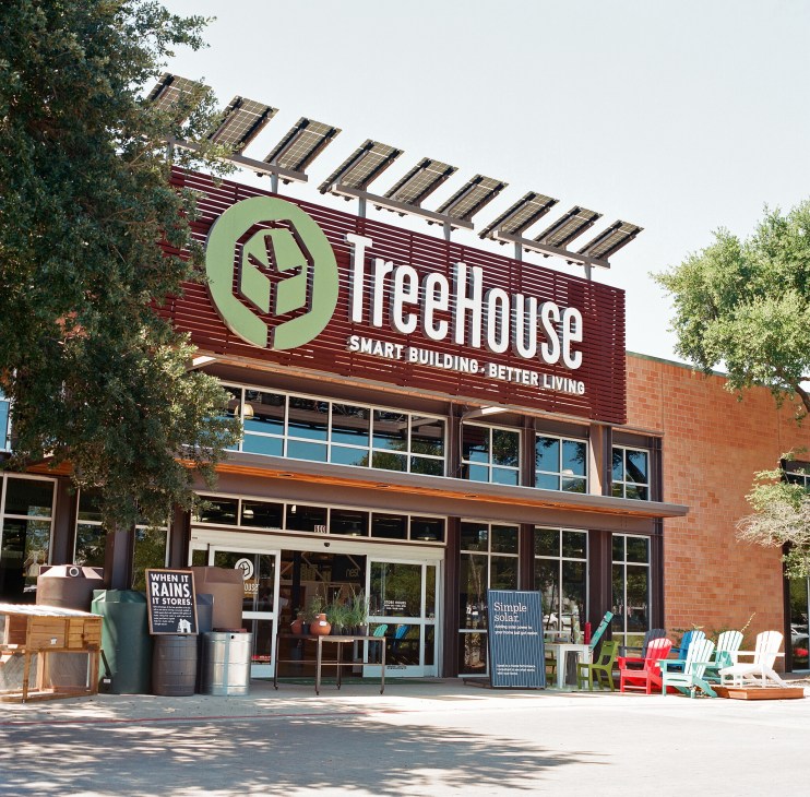 TreeHouse storefront in Austin with green logo, solar panels on roof, and eco-friendly products displayed outside.