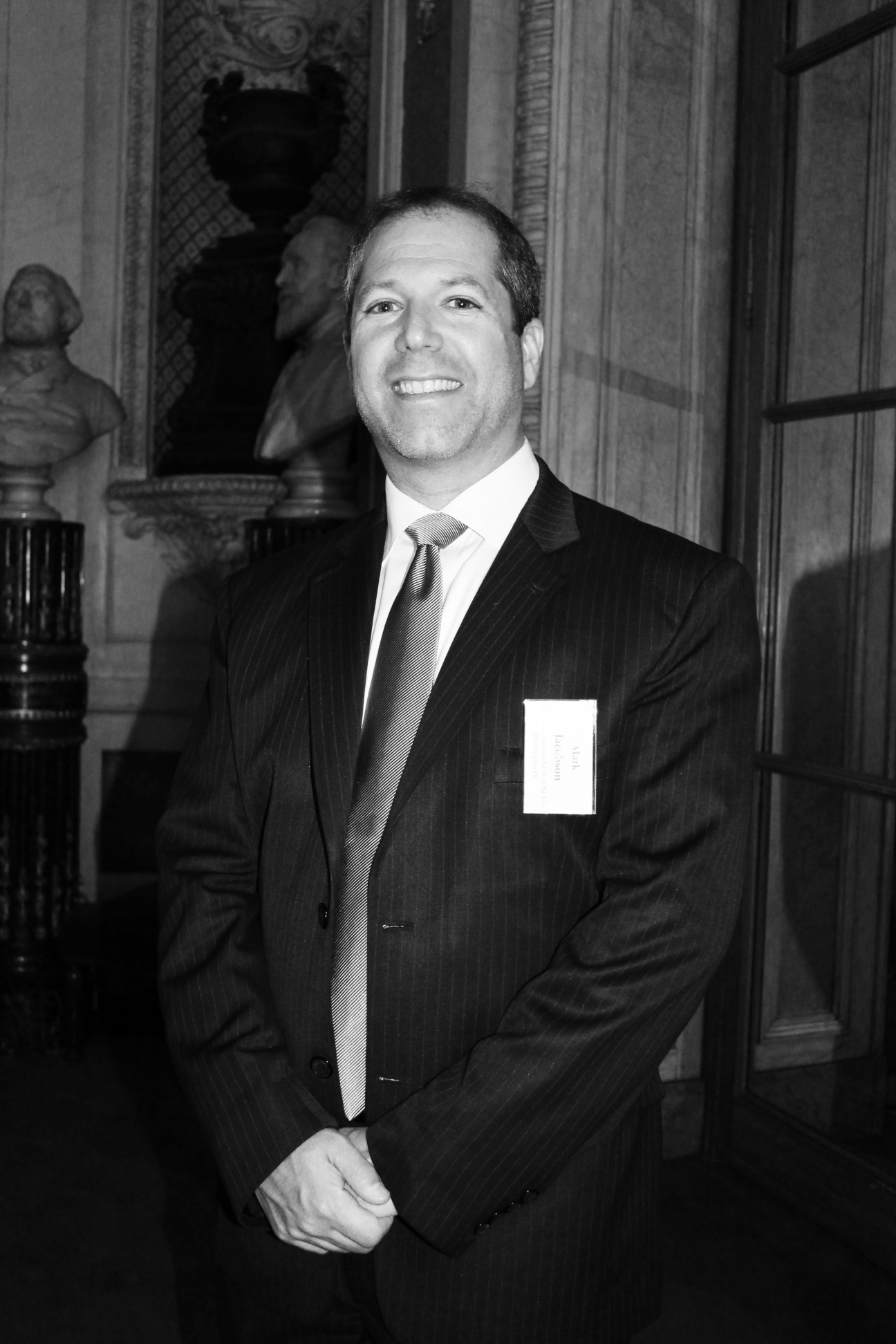 Black and white portrait of Dr Mark R Jacobson in formal business attire indoors.