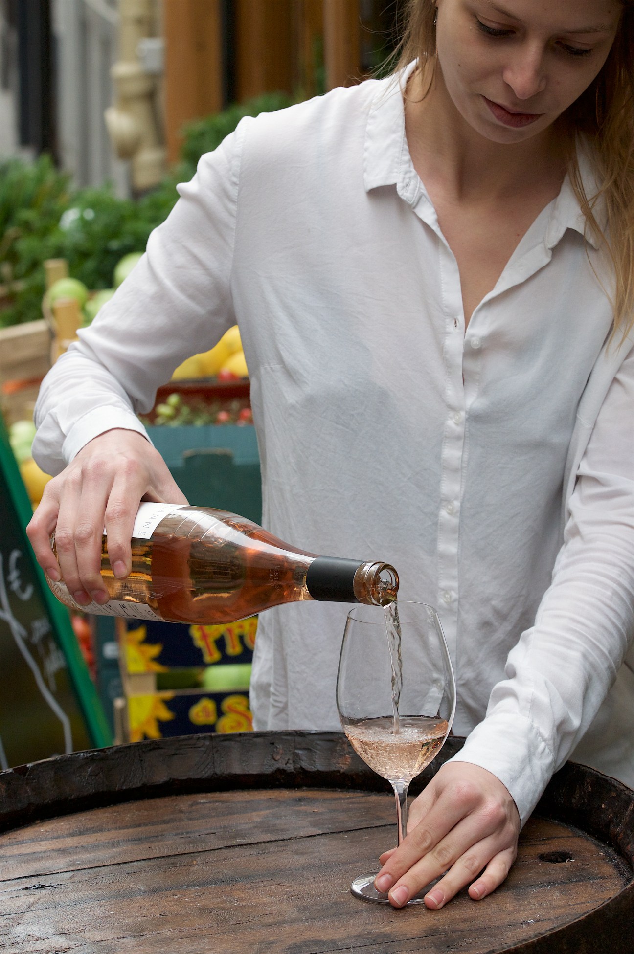 Woman pouring rosé wine into a glass at Frenchie Bar à Vins in Paris