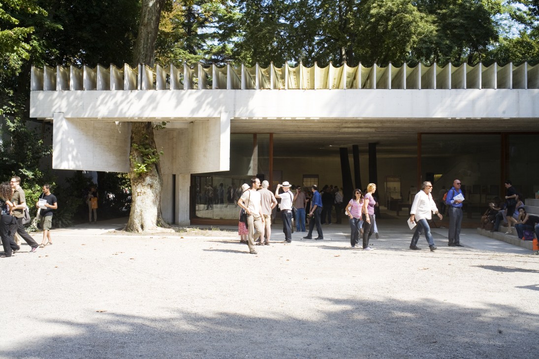 Nordic pavilion by Sverre Fehn at Venice Biennale with white modernist structure and visitors in courtyard.