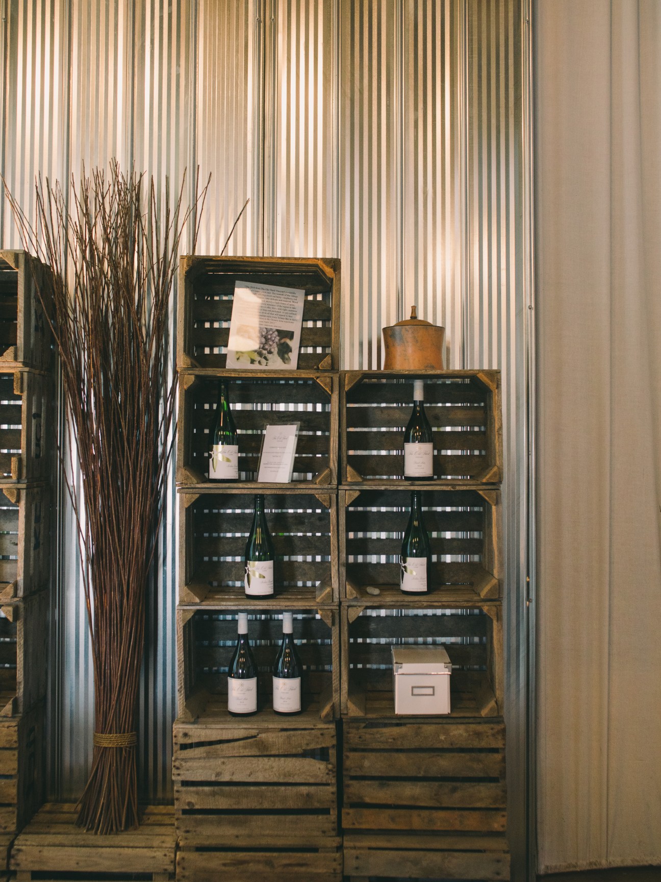 Wooden crate shelving system displaying wine bottles and products at The Old Third winery entrance