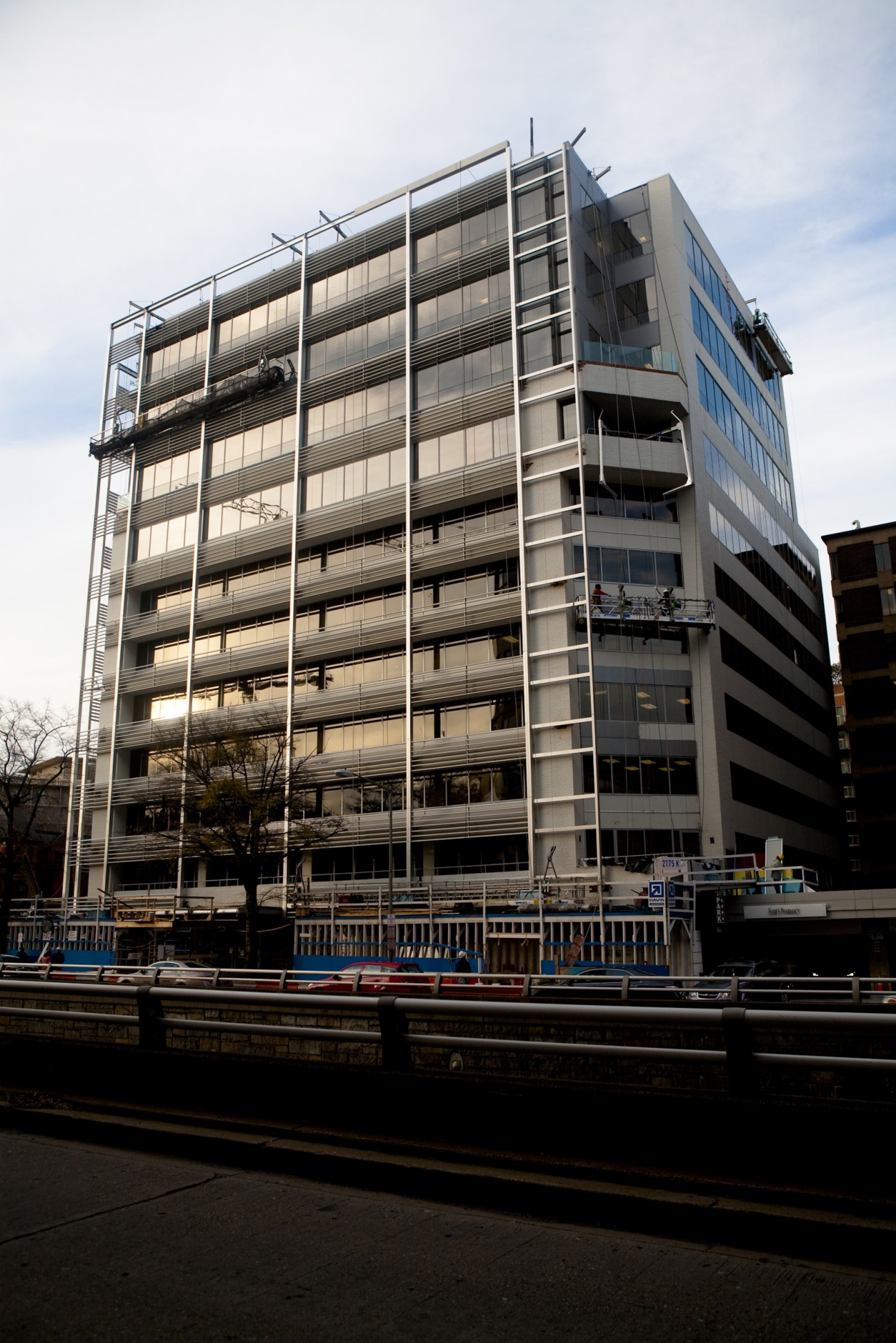 Modern multi-storey building with horizontal metal louvers and glass facade under construction in Washington.